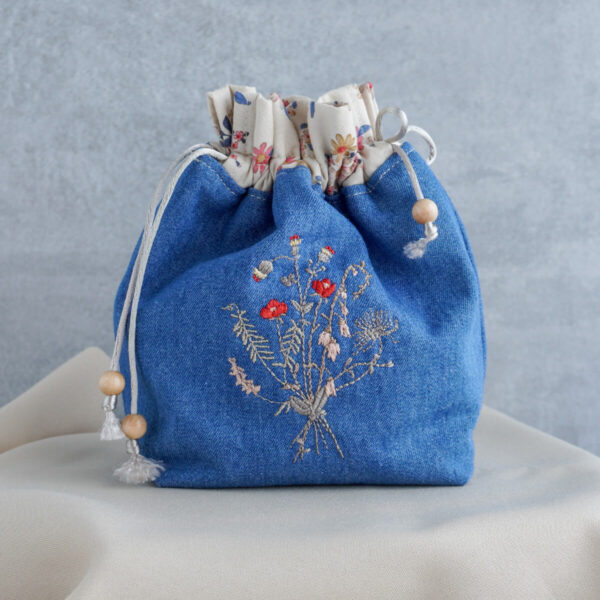 Embroidered denim drawstring bag with red flowers